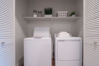 A small laundry room with two washes and a dryer